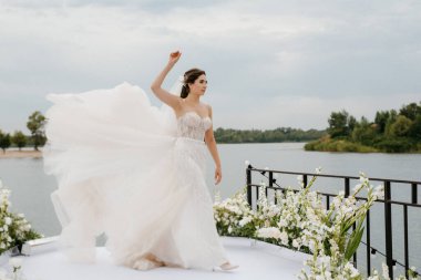 bride against the background of a yellow sunset on a pier near the river