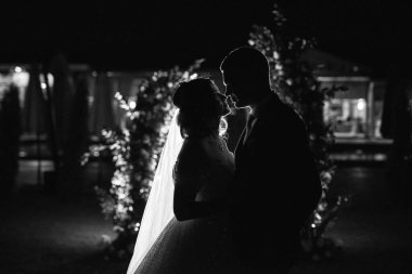 Kız ve erkek, düğün kemerinin arka planında gelin ve damat olarak.