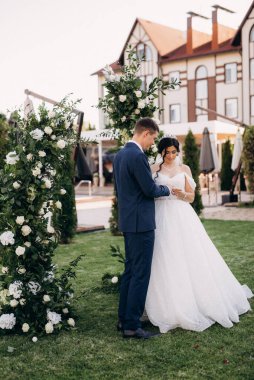 wedding ceremony of the newlyweds on the glade near the restaurant