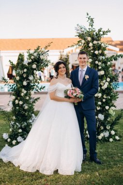 wedding ceremony of the newlyweds on the glade near the restaurant
