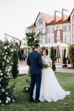 wedding ceremony of the newlyweds on the glade near the restaurant
