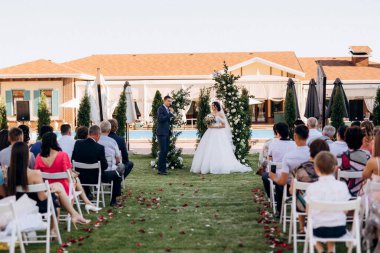 wedding ceremony of the newlyweds on the glade near the restaurant