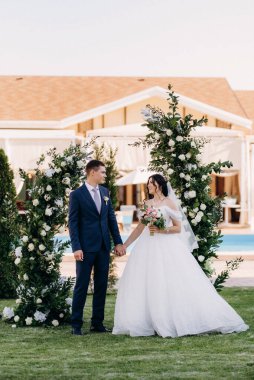 wedding ceremony of the newlyweds on the glade near the restaurant