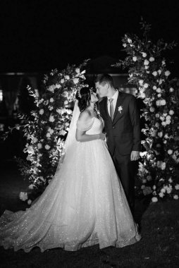 Kız ve erkek, düğün kemerinin arka planında gelin ve damat olarak.