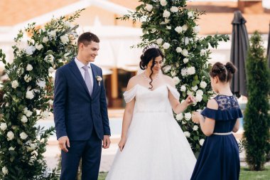 wedding ceremony of the newlyweds on the glade near the restaurant