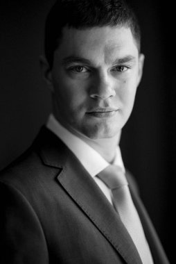 Düğün günü otelde kravatlı, mavi takım elbiseli bir damat portresi.