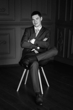 Düğün günü otelde kravatlı, mavi takım elbiseli bir damat portresi.