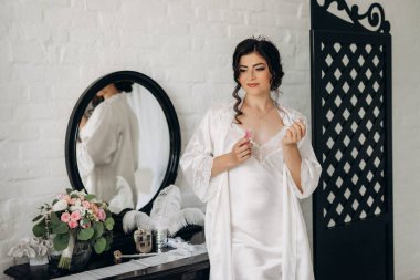 Siyah saçlı gelin kız banyolu damat için hazırlanıyor.