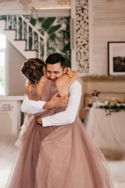 the first dance of the bride and groom inside a restaurant with heavy smoke