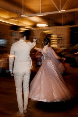 the first dance of the bride and groom inside a restaurant with heavy smoke