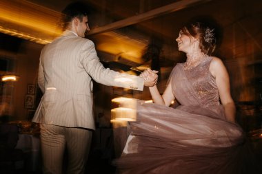 the first dance of the bride and groom inside a restaurant with heavy smoke