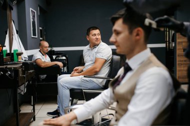 Beyefendinin berber dükkanında sakalını kesen sakallı adam.