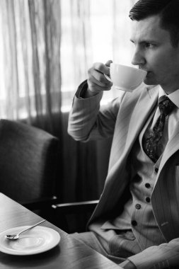 Bej takım elbiseli damadın portresi, parlak bardaki aynalı kravat.