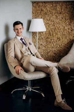 Bej takım elbiseli damadın portresi, parlak bardaki aynalı kravat.