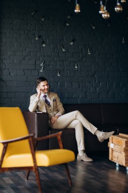 Parlak stüdyoda bej takım elbiseli damat.