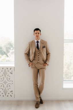 Parlak stüdyoda bej takım elbiseli damat.