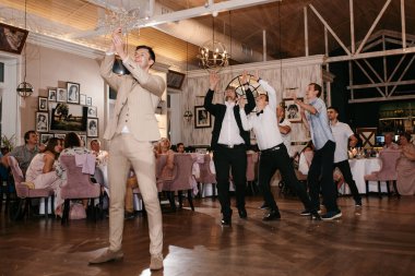 a groom throwing a baseball to his wedding witnesses clipart