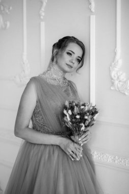 Gelin lavanta renkli pofuduk gelinlik içinde parlak bir stüdyoda buketle