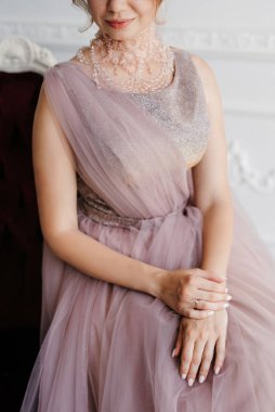 Gelin lavanta renkli pofuduk gelinlik içinde parlak bir stüdyoda buketle