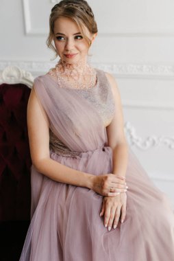 Gelin lavanta renkli pofuduk gelinlik içinde parlak bir stüdyoda buketle