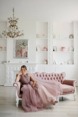 Gelin lavanta renkli pofuduk gelinlik içinde parlak bir stüdyoda buketle