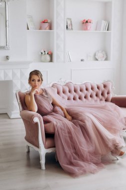 Gelin lavanta renkli pofuduk gelinlik içinde parlak bir stüdyoda buketle