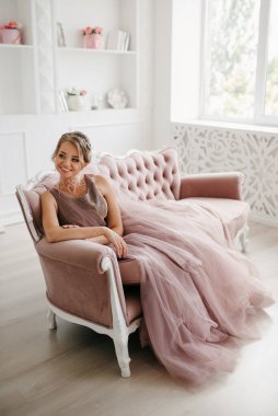 Gelin lavanta renkli pofuduk gelinlik içinde parlak bir stüdyoda buketle