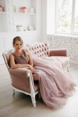 Gelin lavanta renkli pofuduk gelinlik içinde parlak bir stüdyoda buketle