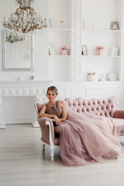 Gelin lavanta renkli pofuduk gelinlik içinde parlak bir stüdyoda buketle