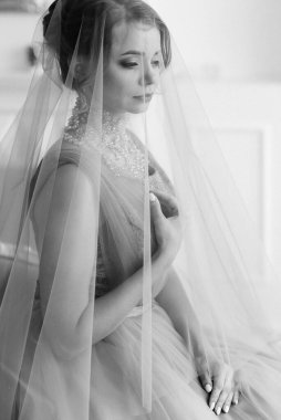 Gelin lavanta renkli pofuduk gelinlik içinde parlak bir stüdyoda buketle