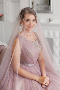 Gelin lavanta renkli pofuduk gelinlik içinde parlak bir stüdyoda buketle