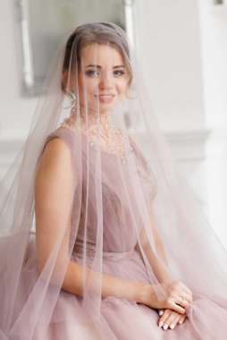 Gelin lavanta renkli pofuduk gelinlik içinde parlak bir stüdyoda buketle