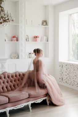 Gelin lavanta renkli pofuduk gelinlik içinde parlak bir stüdyoda buketle