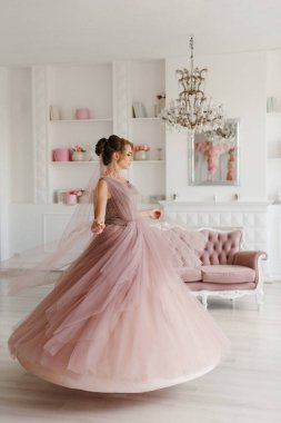 Gelin lavanta renkli pofuduk gelinlik içinde parlak bir stüdyoda buketle