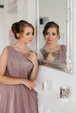 Gelin lavanta renkli pofuduk gelinlik içinde parlak bir stüdyoda buketle