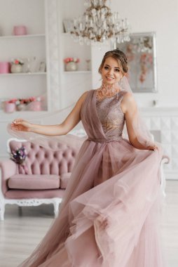 Gelin lavanta renkli pofuduk gelinlik içinde parlak bir stüdyoda buketle