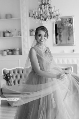 Gelin lavanta renkli pofuduk gelinlik içinde parlak bir stüdyoda buketle