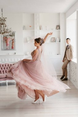 Gelin lavanta renkli pofuduk gelinlik içinde parlak bir stüdyoda buketle