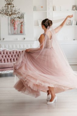 Gelin lavanta renkli pofuduk gelinlik içinde parlak bir stüdyoda buketle