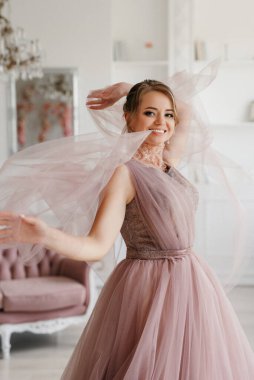 Gelin lavanta renkli pofuduk gelinlik içinde parlak bir stüdyoda buketle