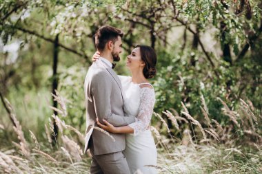 Bir erkek ve bir kız yeni evliler yazın ormanda yürüyorlar.