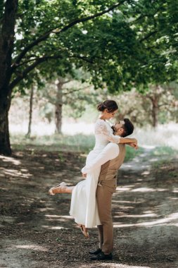 Bir erkek ve bir kız yeni evliler yazın ormanda yürüyorlar.