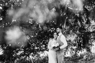 Bir erkek ve bir kız yeni evliler yazın ormanda yürüyorlar.