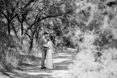 Bir erkek ve bir kız yeni evliler yazın ormanda yürüyorlar.