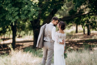 Bir erkek ve bir kız yeni evliler yazın ormanda yürüyorlar.