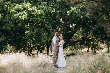 Bir erkek ve bir kız yeni evliler yazın ormanda yürüyorlar.