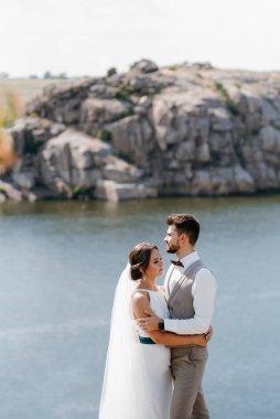 bride blonde girl and groom near the river at sunset light