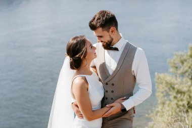 bride blonde girl and groom near the river at sunset light
