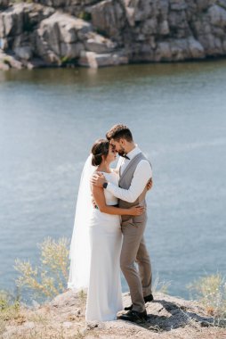 bride blonde girl and groom near the river at sunset light