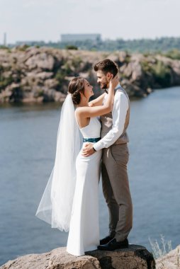 bride blonde girl and groom near the river at sunset light